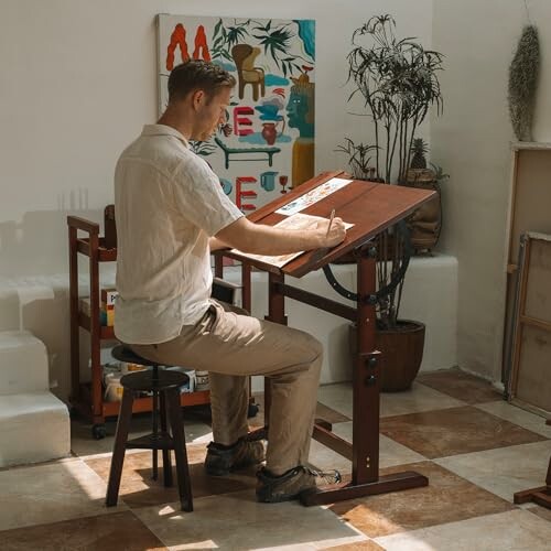 Artist working at a drawing board in a studio