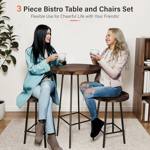 Two women sitting at a bistro table with chairs, holding cups and smiling.