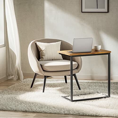 Cozy armchair and small desk with a laptop in a bright room.