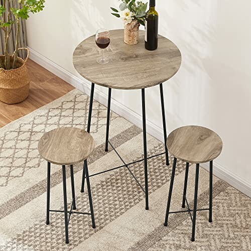 Round wood table with two stools and wine in a cozy room.