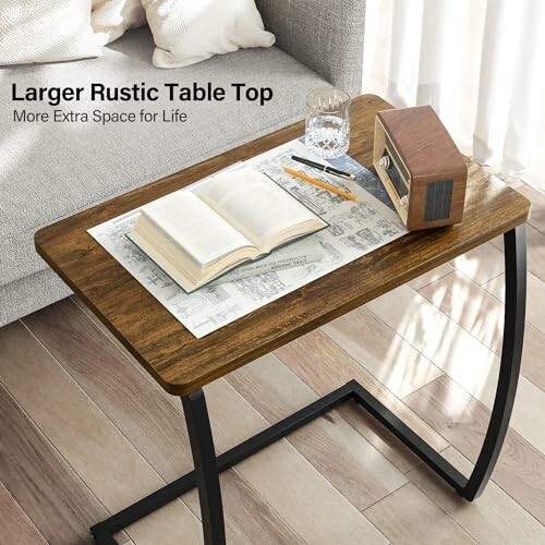 Rustic side table with an open book, glass of water, radio, and pencils.